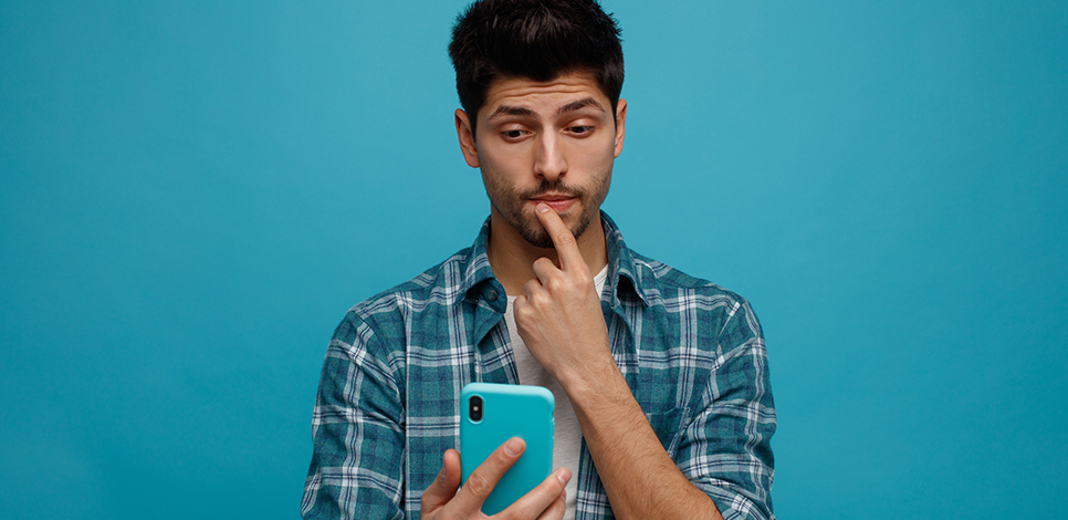 Mann schaut nachdenklich aufs Handy – Ex meldet sich, was tun?