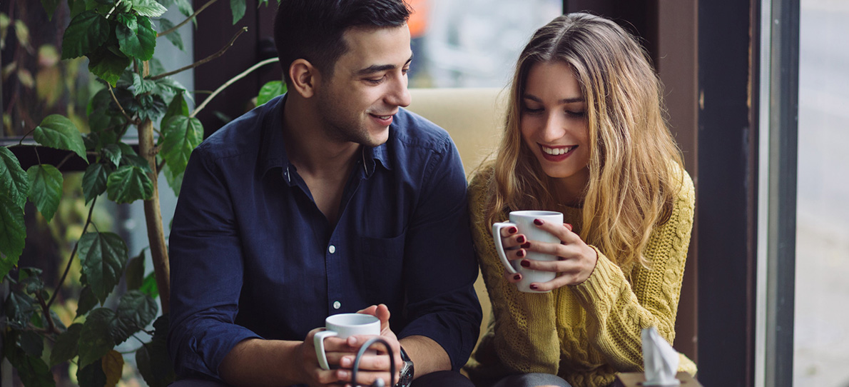 Mann und Frau sitzen bei einem Kaffee und unterhalten sich – symbolisiert das erste Treffen mit der Ex nach einer Trennung.